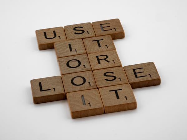 a scrabbled crossword with the words use it or lose it
